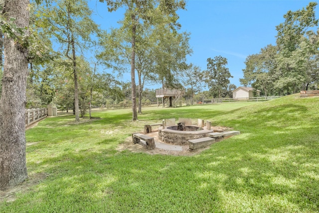 view of yard featuring an outdoor fire pit and fence