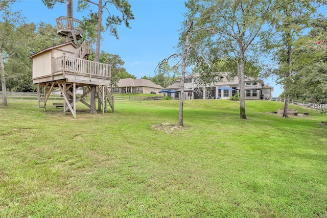 view of yard with a wooden deck, stairs, and fence