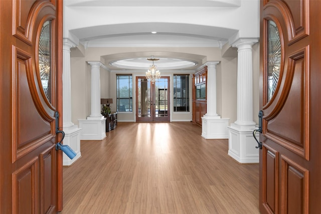 entryway with a decorative wall, french doors, light wood-style floors, and decorative columns