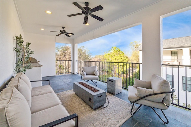 view of patio / terrace with a ceiling fan and an outdoor living space with a fire pit