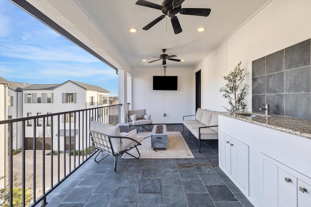 balcony with outdoor lounge area, a sink, and ceiling fan