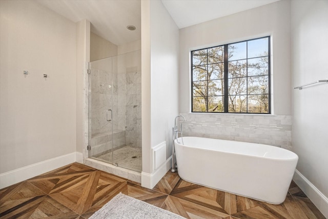 full bathroom featuring a stall shower, baseboards, tile walls, and a freestanding bath