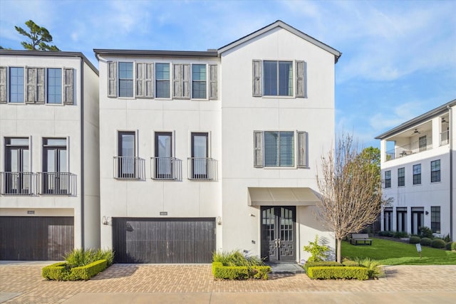 multi unit property featuring driveway, an attached garage, and stucco siding