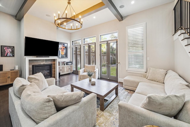 living room with stairway, a glass covered fireplace, wood finished floors, and beamed ceiling