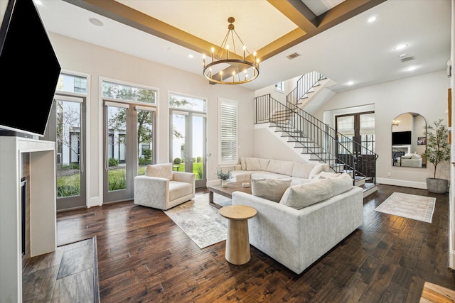 living area with stairs, dark wood-style flooring, and a wealth of natural light