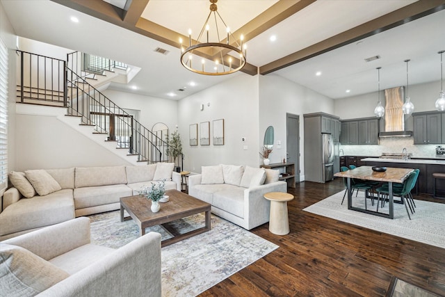 living room featuring stairway, beam ceiling, visible vents, and dark wood-style flooring