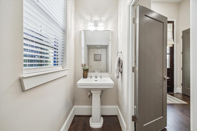 bathroom featuring a sink, baseboards, and wood finished floors