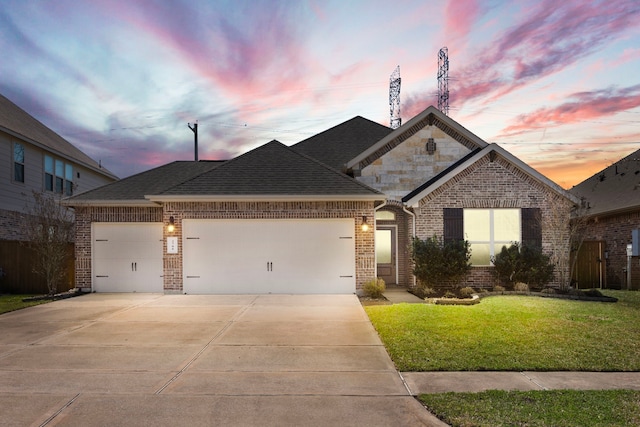 view of front of property featuring a garage, driveway, brick siding, and a lawn