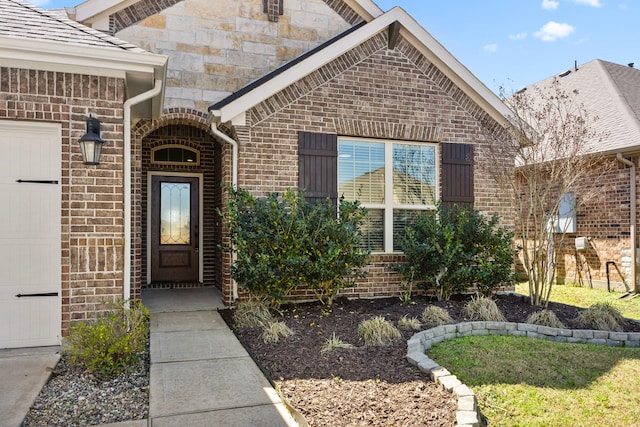 view of exterior entry featuring brick siding