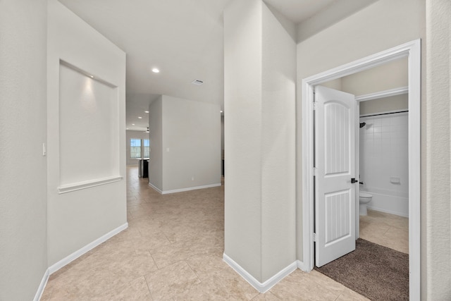 hallway with recessed lighting, light tile patterned flooring, visible vents, and baseboards