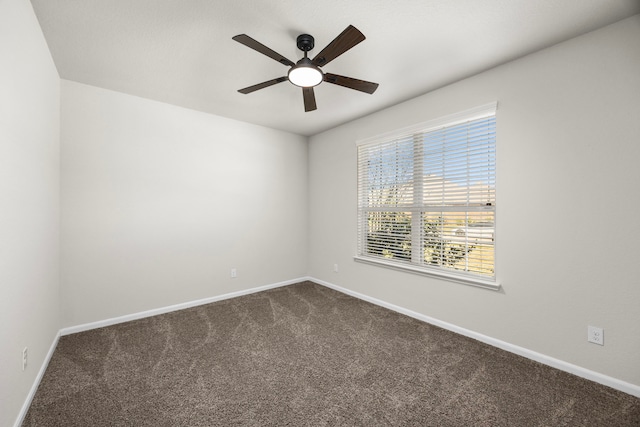 unfurnished room with ceiling fan, dark colored carpet, and baseboards