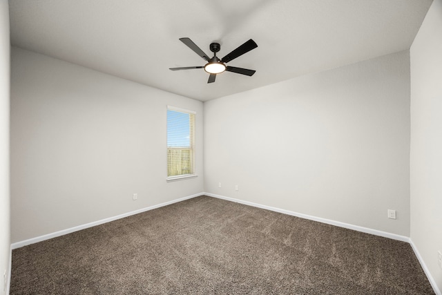 unfurnished room with dark carpet, a ceiling fan, and baseboards