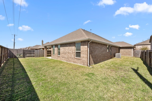 back of house featuring brick siding, central air condition unit, a shingled roof, a lawn, and a fenced backyard