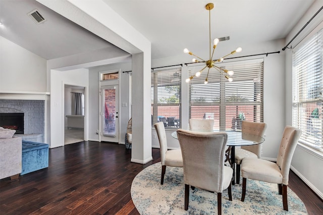 dining area with baseboards, visible vents, a fireplace, dark wood-type flooring, and a chandelier