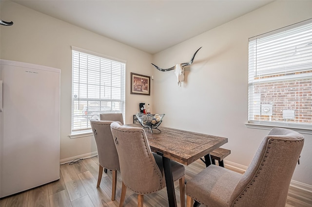 dining room featuring light wood-style floors and baseboards