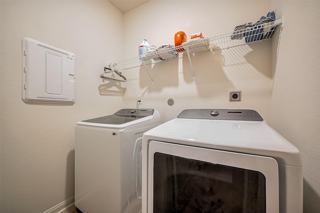 washroom with laundry area, independent washer and dryer, and baseboards