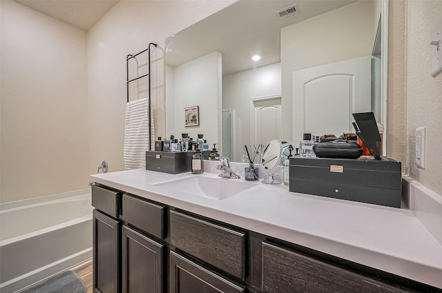 bathroom featuring visible vents, a shower with shower door, vanity, wood finished floors, and a bath