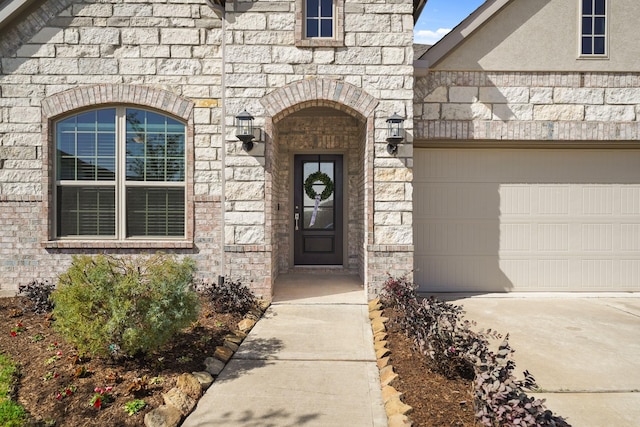 doorway to property with stone siding, brick siding, and an attached garage