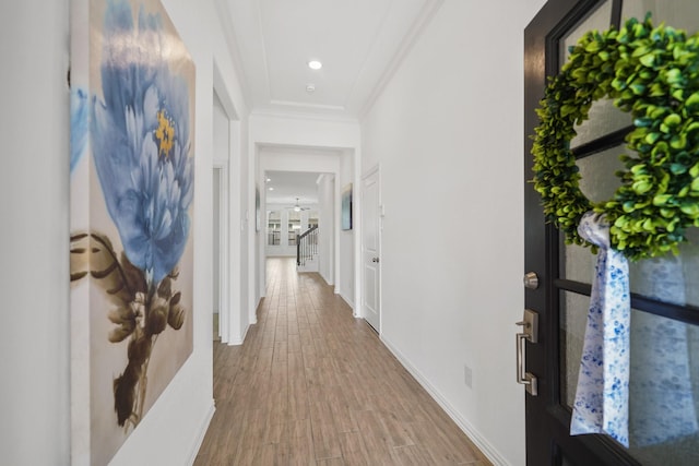 hallway with recessed lighting, baseboards, crown molding, and wood finished floors