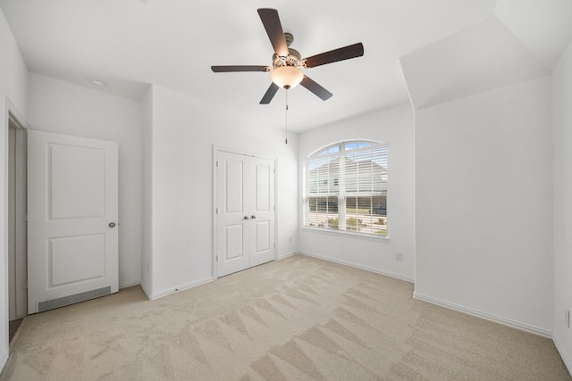 unfurnished bedroom with a closet, carpet, a ceiling fan, and baseboards