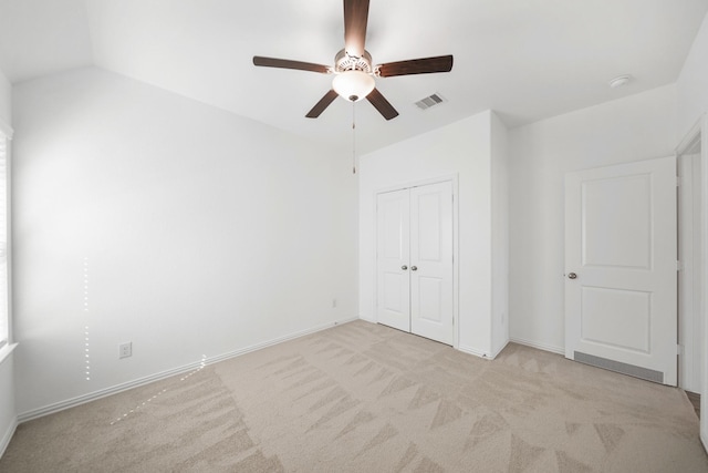 unfurnished bedroom featuring baseboards, visible vents, a closet, and light colored carpet