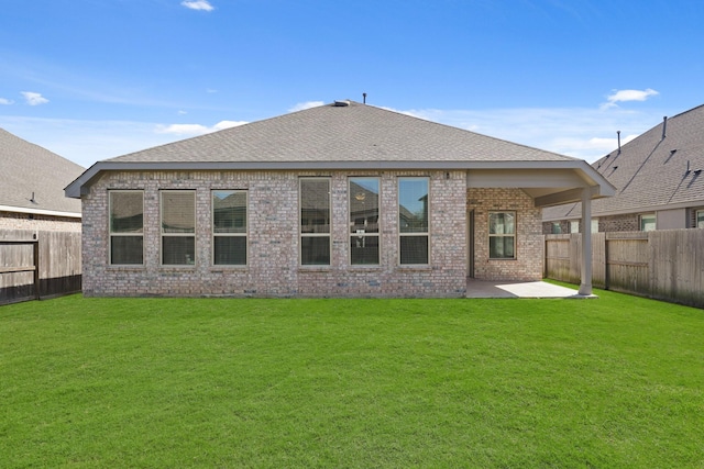 rear view of house featuring a yard, brick siding, a patio, and a fenced backyard