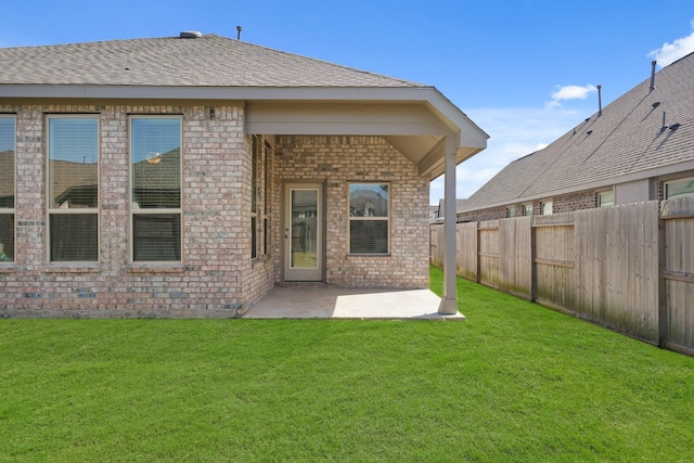 back of property featuring a fenced backyard, brick siding, and a lawn