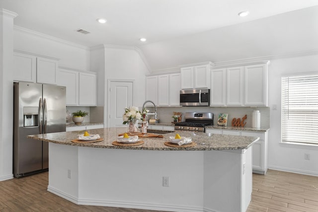 kitchen with light wood-style floors, white cabinetry, stainless steel appliances, and a sink