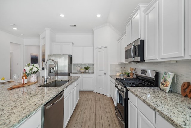 kitchen featuring stainless steel appliances, visible vents, a sink, and white cabinetry