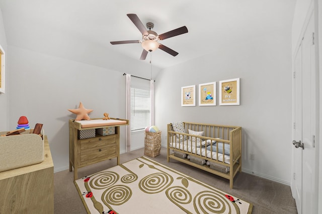 carpeted bedroom with a nursery area, a ceiling fan, and baseboards