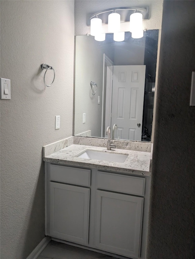 bathroom with a textured wall and vanity