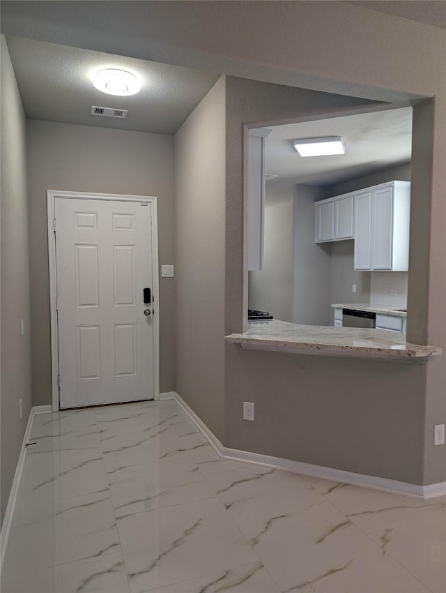 foyer with marble finish floor, visible vents, and baseboards