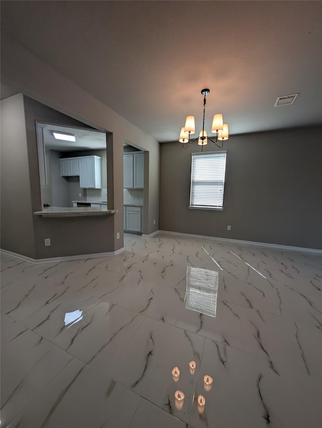 interior space featuring a chandelier, marble finish floor, visible vents, and baseboards