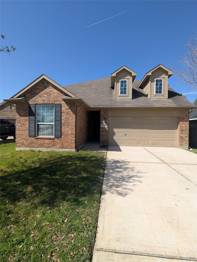 view of front of property featuring a garage, a front yard, concrete driveway, and brick siding