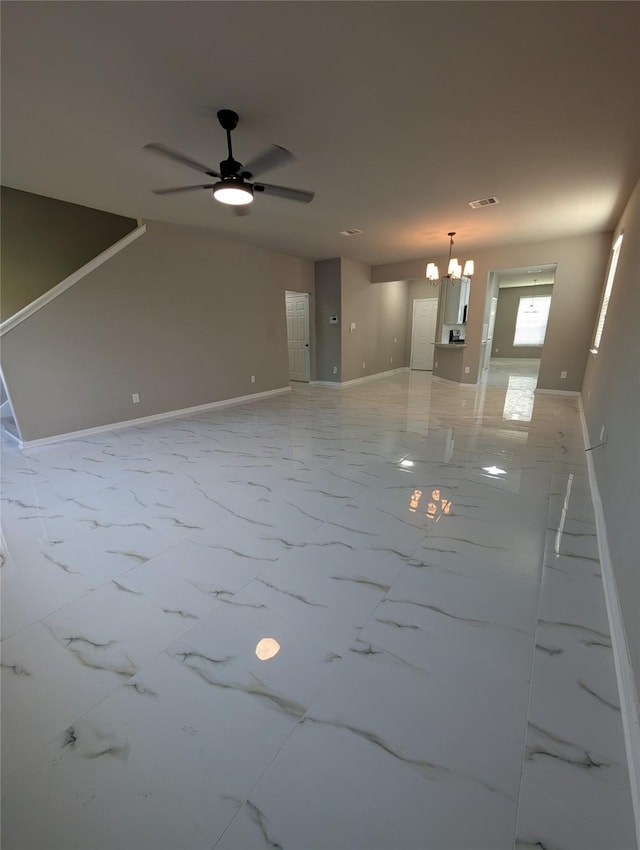 unfurnished living room with marble finish floor, visible vents, baseboards, and ceiling fan with notable chandelier