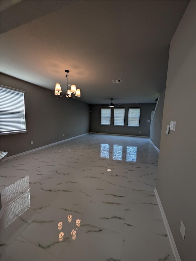 empty room with marble finish floor, visible vents, and a healthy amount of sunlight