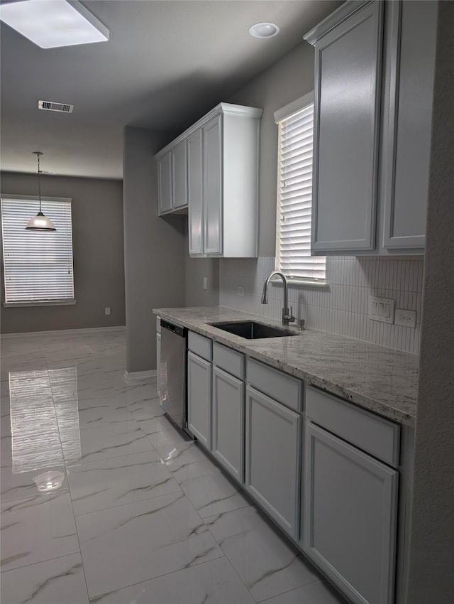 kitchen with marble finish floor, visible vents, stainless steel dishwasher, a sink, and light stone countertops