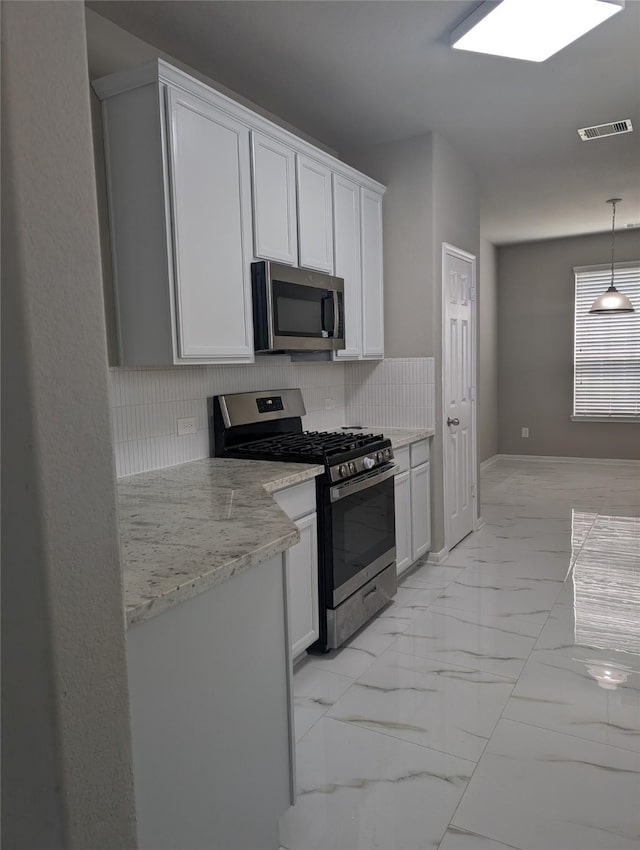 kitchen with tasteful backsplash, visible vents, white cabinets, marble finish floor, and stainless steel appliances