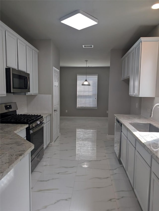 kitchen featuring light stone counters, marble finish floor, visible vents, appliances with stainless steel finishes, and a sink