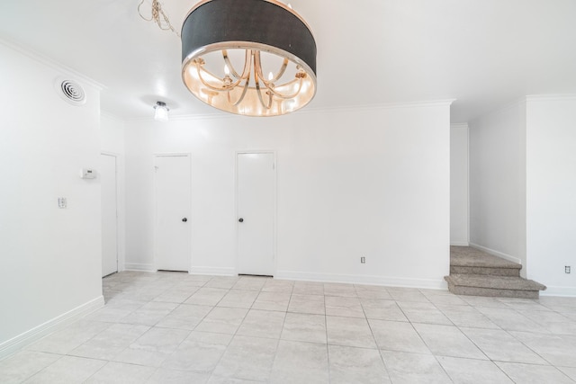 spare room with an inviting chandelier, baseboards, visible vents, and crown molding