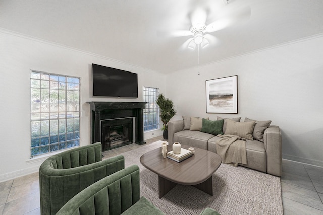 tiled living room with ornamental molding, baseboards, ceiling fan, and a fireplace with flush hearth