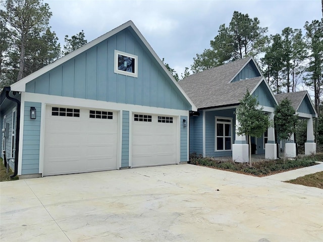 view of front of home with board and batten siding, a shingled roof, an attached garage, and concrete driveway