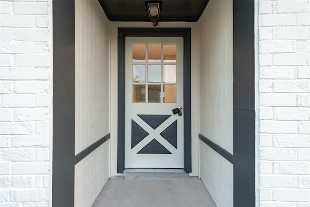 view of exterior entry featuring brick siding