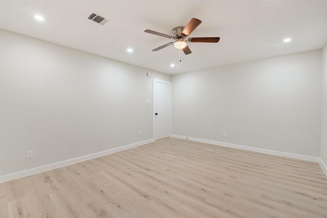 spare room with light wood-style floors, visible vents, ceiling fan, and baseboards