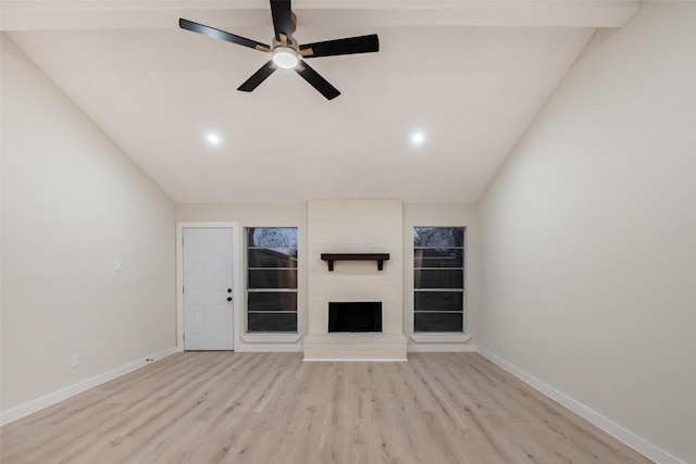 unfurnished living room with baseboards, lofted ceiling, ceiling fan, light wood-type flooring, and a fireplace