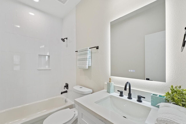 bathroom with shower / washtub combination, a textured wall, vanity, and toilet