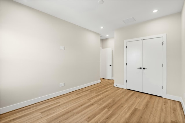 unfurnished bedroom featuring light wood-style floors, recessed lighting, a closet, and baseboards