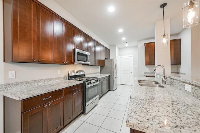 kitchen featuring light stone counters, light tile patterned floors, stainless steel appliances, recessed lighting, and a sink