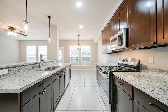 kitchen featuring appliances with stainless steel finishes, a wealth of natural light, a sink, and light tile patterned floors