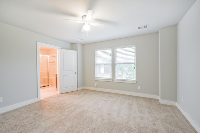 unfurnished room with baseboards, a ceiling fan, visible vents, and light colored carpet